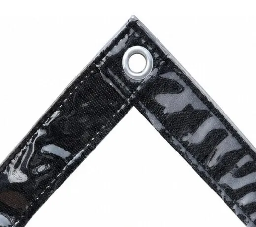 Silver corrosion-resistant metal grommet set into the black reinforced webbing edge of a clear PVC tarpaulin